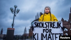FILE - Swedish girl Greta Thunberg, 15, holds a placard reading "School strike for the climate" during a manifestation against climate change outside the Swedish parliament in Stockholm, Sweden, Nov. 30, 2018.