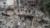 Луѓе се собираат на урнатините на болничкиот центар што беше уништен од израелски воздушен напад рано во средата во јужен Либан, 27 март 2024 година