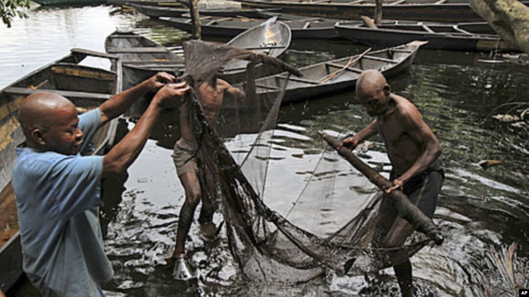 Fishermen sort out their fishing net at the bank of a polluted river in Bidere community in Ogoniland in Nigeria's delta region, August 20, 2011.