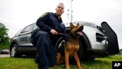 Virginia State Police K-9 Officer Tyler Fridley, poses with his dog, Aries, in Richmond, Va., May 10, 2021. Drug-sniffing dogs in Virginia are being forced into early retirement as the state prepares for legal use of recreational marijuana July 1.