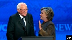 Fie - Hillary Clinton speaks to Bernie Sanders during a break at the Democratic presidential primary debate, Dec. 19, 2015, Manchester, N.H. 