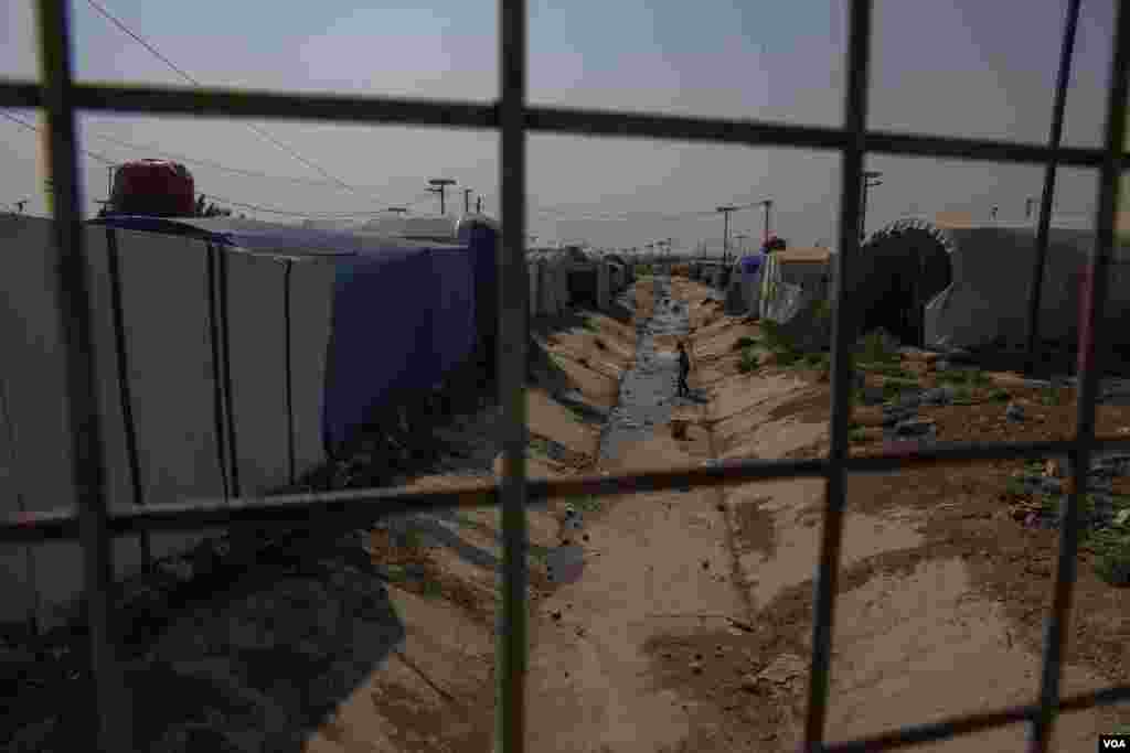 A young boy plays in a dried canal that crosses Roj Camp on Oct. 13, 2024. (Diego Baravelli/VOA) 