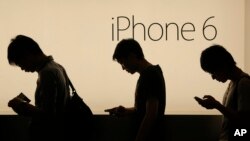 FILE - People wait to buy the new Apple iPhone 6 and 6 Plus devices outside an Apple store in Hong Kong, Sept. 19, 2014. Apple is embroiled in a Chinese patent dispute that threatens to block future sales of the iPhone 6 in Beijing unless the company can overturn a regulator's recent ruling. 