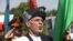 Afghan President Ashraf Ghani sings the national anthem after putting flowers on the "Independence Minaret" monument during Independence Day celebrations at Defense Ministry in Kabul, Aug. 18, 2016. 
