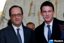 French President Francois Hollande (left) speaks with Prime Minister Manuel Valls as he leaves a weekly cabinet meeting. Valls is widely expected to announce a run in the coming days.