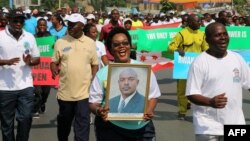 Seorang perempuan memegang foto Presiden Burundi, Pierre Nkurunziza, dalam sebuah demonstrasi di Bujumbura, Mei 2016. 