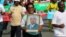 FILE - A woman holds up a picture of Burundi's President Pierre Nkurunziza during a rally in Bujumbura on May 14, 2016, commemorating the one-year anniversary of the failed attempt of a government coup. Authorities in Burundi arrested 11 students last week for defacing a photo of President Pierre Nkurunziza.