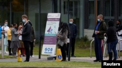 People line up outside a mobile vaccination center, amid the outbreak of the coronavirus disease, in Bolton, Britain, May 13, 2021.