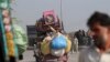 FILE - A man fleeing a military offensive against militants in the Khyber Agency, travels on a vehicle laden with his family's belongings on the outskirts of Peshawar in Pakistan's Khyber-Pakhtunkhwa province.