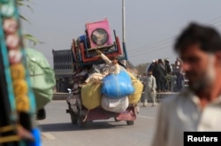 FILE - A man fleeing a military offensive against militants in the Khyber Agency travels on a vehicle laden with his family's belongings on the outskirts of Peshawar in Pakistan's Khyber-Pakhtunkhwa province, Oct. 30, 2014.