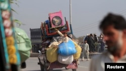 FILE - A man fleeing a military offensive against militants in the Khyber Agency, travels on a vehicle laden with his family's belongings on the outskirts of Peshawar in Pakistan's Khyber-Pakhtunkhwa province.