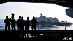 2010年4月7日，美国海军士兵观看自由号滨海战斗舰与卡尔.文森号航空母舰在太平洋海面进行海上加油。（美国海军拍摄） 