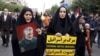FILE - Iranian women, one of them holding an anti-Israeli placard, attend a pro-Palestinian rally, in Tehran, Iran, Oct. 13, 2023. The woman at left holds a portrait of the late Iranian Revolutionary Guard Gen. Qassem Soleimani, who was killed in a U.S. drone attack in 2020.