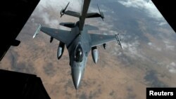 FILE - A US Air Force F-16 receives fuel from a fuel boom over Iraq and Syria air space, March 15, 2017. 