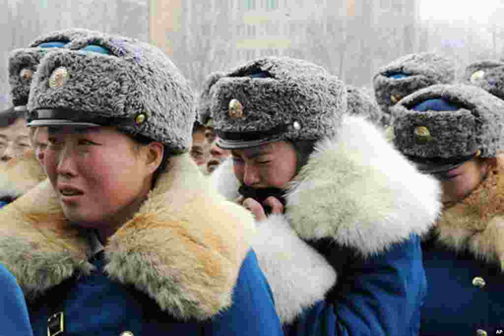 North Korean traffic control women react as they make a condolence call for deceased leader Kim Jong-il in Pyongyang in this photo taken by Kyodo December 21, 2011. Picture taken December 21, 2011. Mandatory Credit REUTERS/Kyodo (NORTH KOREA - Tags: 