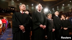 U.S. Supreme Court Chief Justice John Roberts (L) stands with fellow Justices Anthony Kennedy (2nd from L), Ruth Bader Ginsburg, Stephen Breyer and Elena Kagan (R) prior to President Barack Obama's State of the Union speech on Capitol Hill in Washington, January 28, 2014
