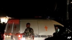 A soldier stands near an ambulance carrying victims of a bomb blast near a military barracks in Nigeria's capital Abuja, 31 Dec 2010