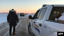 FILE - This photo released Jan. 20, 2022, by the Royal Canadian Mounted Police in Emerson, Manitoba, shows RCMP officers near the Canada-US border. Canada and the U.S. have agreed to trace guns that are intercepted at the border. (RCMP/AFP)