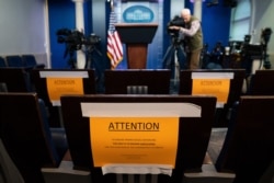 Signs in the briefing room of the White House indicate social distancing measures being taken to separate reporters working at the White House, March 16, 2020.