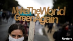 A demonstrator holds a sign as Fridays for Future activists protest calling for a "Global Day of Climate Action" in Berlin, Germany, Sept. 25, 2020. 