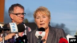Quebec Premier Pauline Marois (foreground) speaks to reporters in Lac Megantic in this July 6, 2013, file photo.