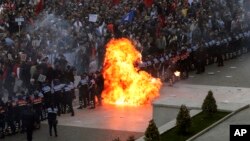 Flames rise from a petrol bomb thrown toward a police line that was blocking anti-government protesters at a rally in Tirana, Albania, May 11, 2019. Protesters demand that the Socialist government resign and call an early parliamentary election.