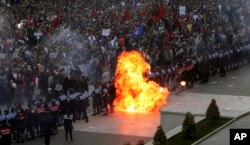 Flames rise from a Molotov cocktail thrown toward a police line that was blocking anti-government protesters at a rally in Tirana, Albania, May 11, 2019. Protesters demand that the Socialist government resign and call for early parliamentary elections.