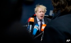 British Foreign Secretary Boris Johnson speaks with the media as he arrives for a meeting of EU foreign ministers at the Europa building in Brussels on Monday, March 19, 2018.