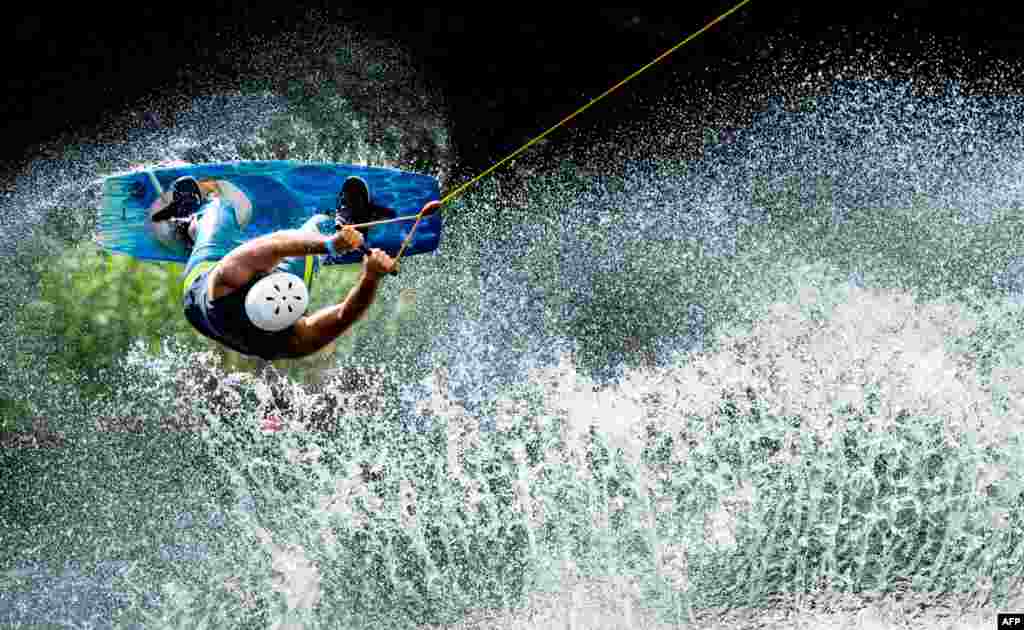 A man jumps with his wakeboard at the water ski facility at the Blauer See in Garbsen, Germany.