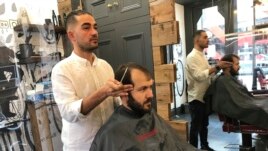 Rado Asatrian cuts a customer's hair at Man-oj hair salon in London's financial district, Thursday, September 9, 2021. Before COVID-19, Asatrian usually had 10 to 15 customers a day, but now it’s down to three or four. (AP Photo/Kelvin Chan)