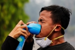 A youth inhales from an oxygen can as he being treated during a Global Climate Strike rally as smog covers the city because of the forest fires in Palangka Raya, Central Kalimantan province, Indonesia, Sept. 20, 2019.