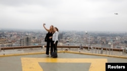 FILE - Tourists take a selfie from an observation point on the top of the Kenyatta International Convention Centre in Nairobi, Kenya, June 21, 2019. 