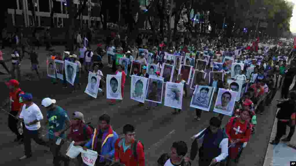 Relatives holding posters with images of the missing students march in protest for the disappearance of 43 students in the state of Guerrero, in Mexico City, Nov. 5, 2014. 