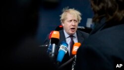 British Foreign Secretary Boris Johnson speaks with the media as he arrives for a meeting of EU foreign ministers at the Europa building in Brussels on Monday, March 19, 2018. 