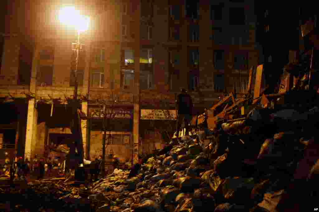 Um manifestante anti-governo parado no cimo da barricada na Praça da Independência em Kiev, Fev. 20, 2014.