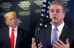 FILE - Director-General of World Trade Organization Roberto Azevedo speaks next to U.S. President Donald Trump during a news conference at the 50th World Economic Forum in Davos, Switzerland, Jan. 22, 2020.