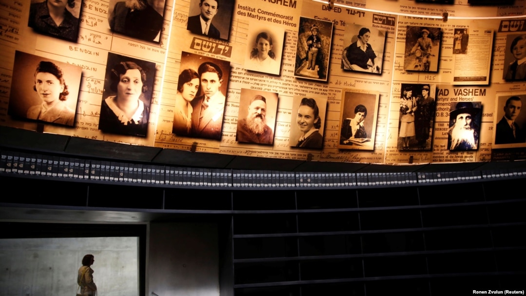 Seorang perempuan berdiri di dekat foto-foto orang Yahudi yang terbunuh dalam Holocaust di Museum Holocaust di Yerusalem. WNI berdarah Yahudi Yaakov Baruch membuka pameran foto dan museum pertama Holocaust di Sulawesi Utara. (Foto: REUTERS/Ronen Zvulun)