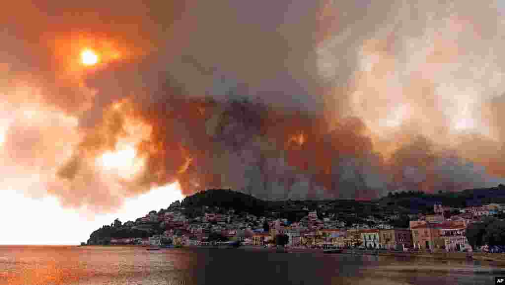 Flames burn on the mountain near Limni village on the island of Evia, about 160 kilometers (100 miles) north of Athens. Greece grappled with the worst heatwave in decades that strained the national power supply and fueled wildfires.