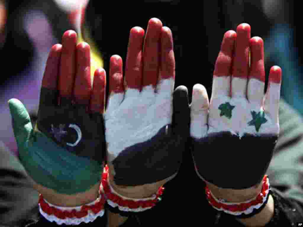 Yemeni female protesters painted their hands with colors of the pre-Gadhafi Libya, Yemen and Syria flags during a demonstration demanding the resignation of Yemen.s president. (AP)