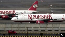 A car moves past Kingfisher Airlines aircraft parked at the airport in New Delhi February 21, 2012.