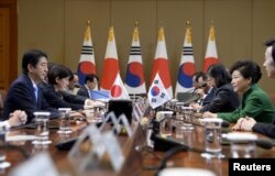 Japanese Prime Minister Shinzo Abe (L) talks with South Korean President Park Geun-Hye (R) during their meeting at the presidential house in Seoul, South Korea, November 2, 2015.