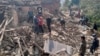 Nepalese villagers stand amidst the debris of their mudhouses after an earthquake in Doti district, Nepal, Wednesday, Nov.9, 2022.