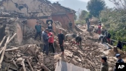 Nepalese villagers stand amidst the debris of their mudhouses after an earthquake in Doti district, Nepal, Wednesday, Nov.9, 2022. 