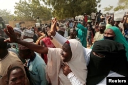 FILE - People gather to receive schoolboys who were rescued by the Nigerian security forces in Katsina, Nigeria, Dec. 18, 2020.