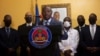 Interim Prime Minister Claude Joseph gives a press conference in Port-au-Prince, July 13, 2021. A picture of late Haitian President Jovenel Moise, who was assassinated in his home on July 7, hangs on the wall.