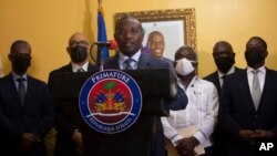 Interim Prime Minister Claude Joseph gives a press conference in Port-au-Prince, July 13, 2021. A picture of late Haitian President Jovenel Moise, who was assassinated in his home on July 7, hangs on the wall.