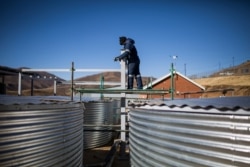 FILE - A worker checks on structures at a facility that grows legal cannabis near Marakabei, Lesotho, Aug. 6, 2019.