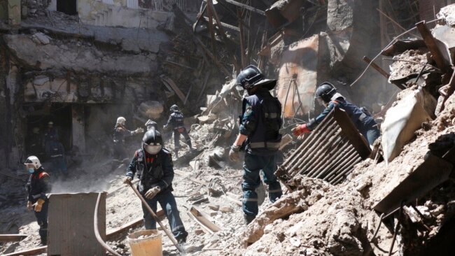 Donetsk People Republic Emergency Situations Ministry employees clear rubble at the side of the damaged Mariupol theater building during heavy fighting in Mariupol, in territory under the government of the Donetsk People's Republic, eastern Ukraine, May 1