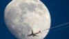 Airbus A330 of Air China company flying from Frankfurt to Beijing is silhouetted against the moon as it flies over St. Petersburg, Russia, April 13, 2022. 