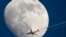 Airbus A330 of Air China company flying from Frankfurt to Beijing is silhouetted against the moon as it flies over St. Petersburg, Russia, April 13, 2022. 